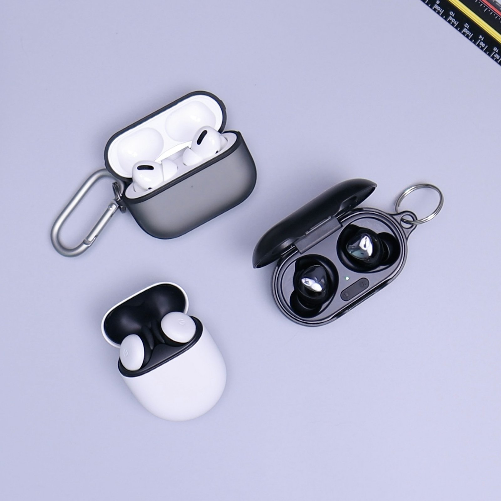 Black wireless earbuds and case on a light surface
